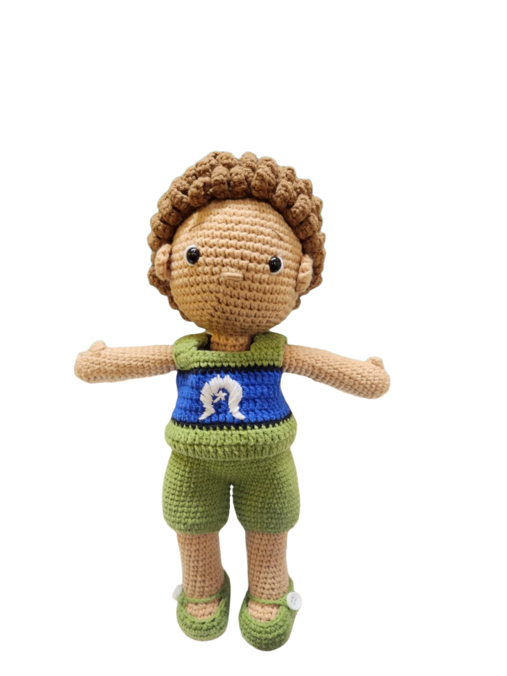 Suzie's Sunshine Dolls Malakai, a crocheted doll with short brown hair, wearing green shorts and a blue top with a white Dhari symbol.