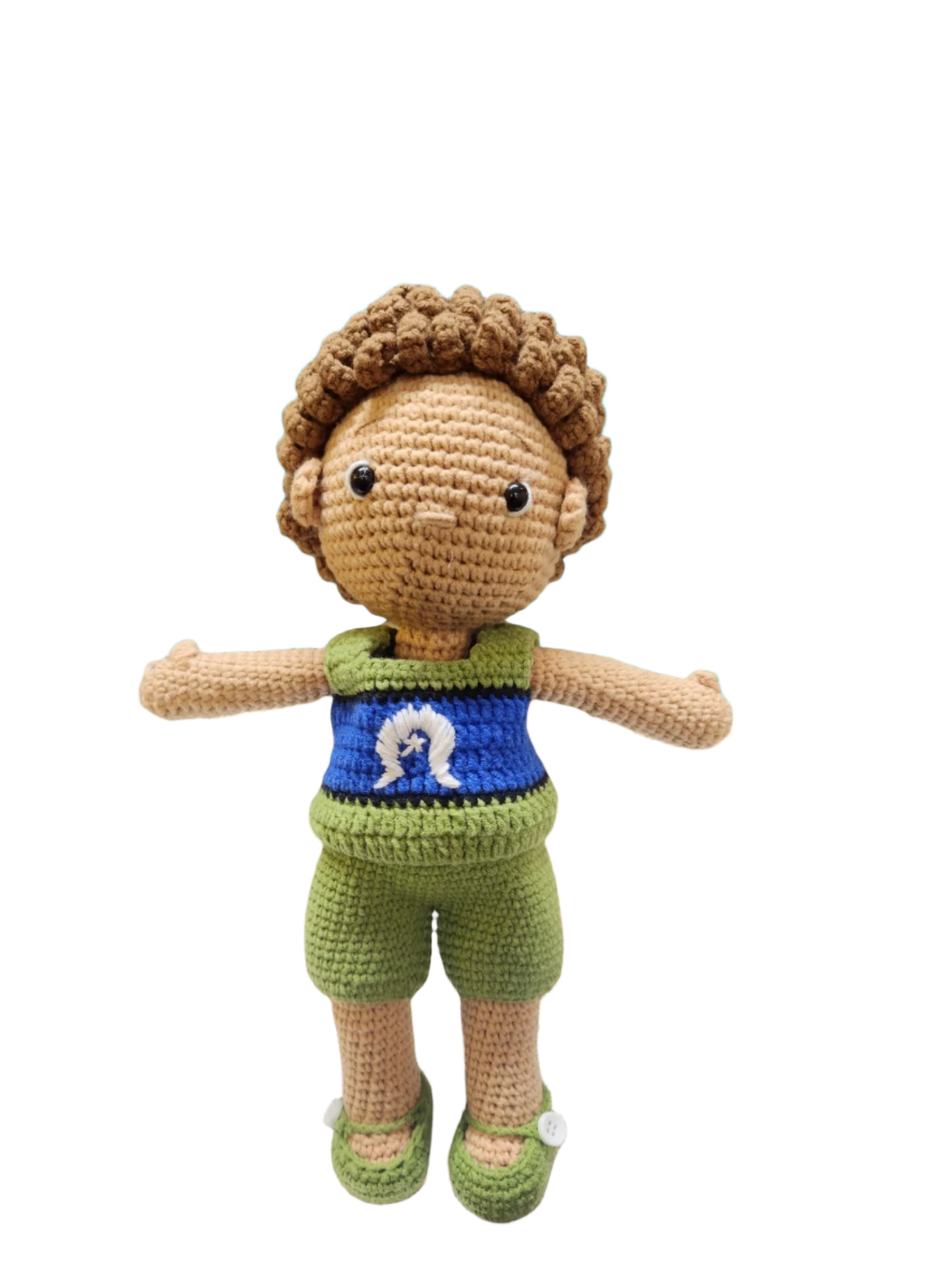 Suzie's Sunshine Dolls Malakai, a crocheted doll with short brown hair, wearing green shorts and a blue top with a white Dhari symbol.