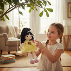 Suzie's Sunshine Dolls Matilda, a handmade crochet doll with black curly hair, wearing a yellow dress with rosebuds and a white lace bow.