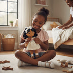 Suzie's Sunshine Dolls Matilda, a handmade crochet doll with black curly hair, wearing a cream knitted dress with pink rosebuds and a white lace bow.