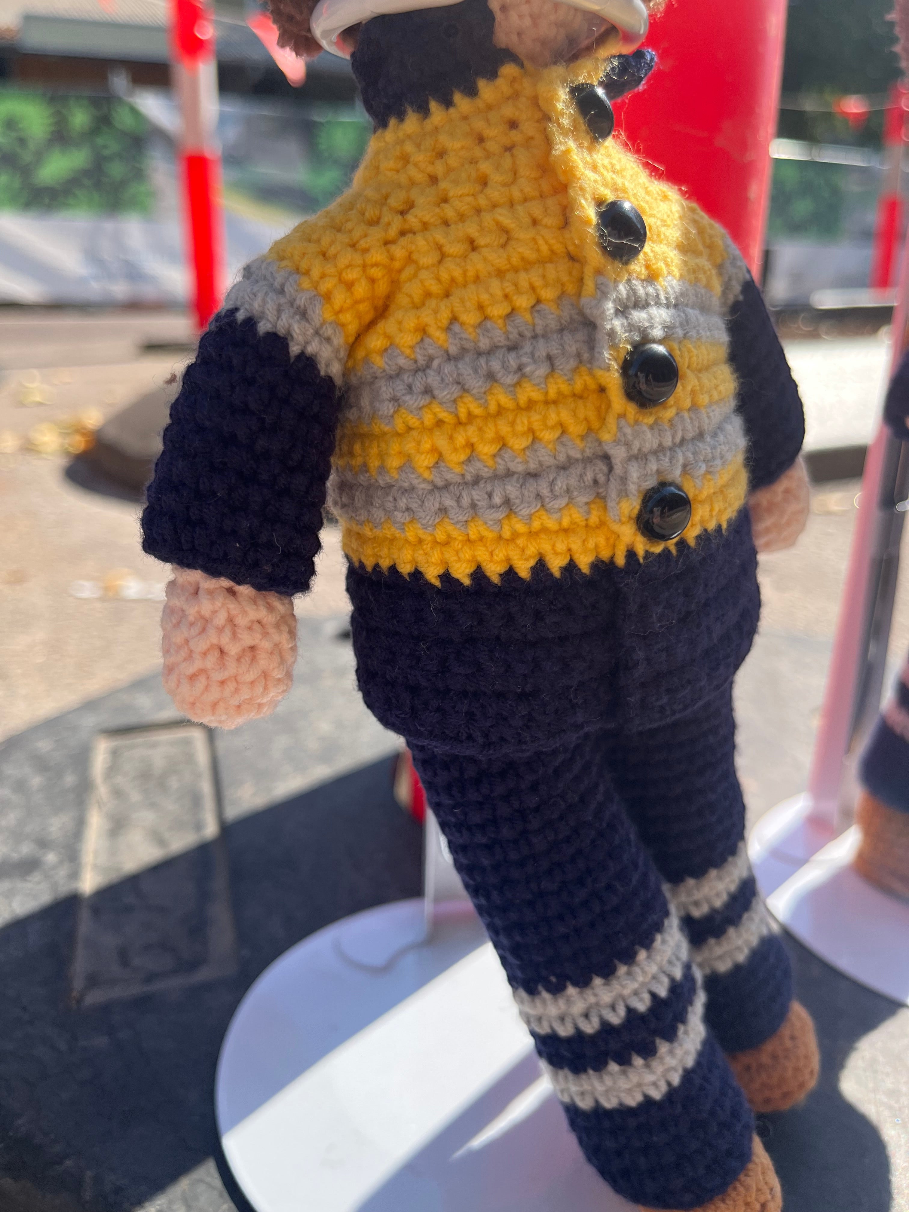 Suzie's Sunshine Dolls Miner/Tradie doll in yellow hi-vis jacket, navy pants, and striped socks. Handmade crochet toy.