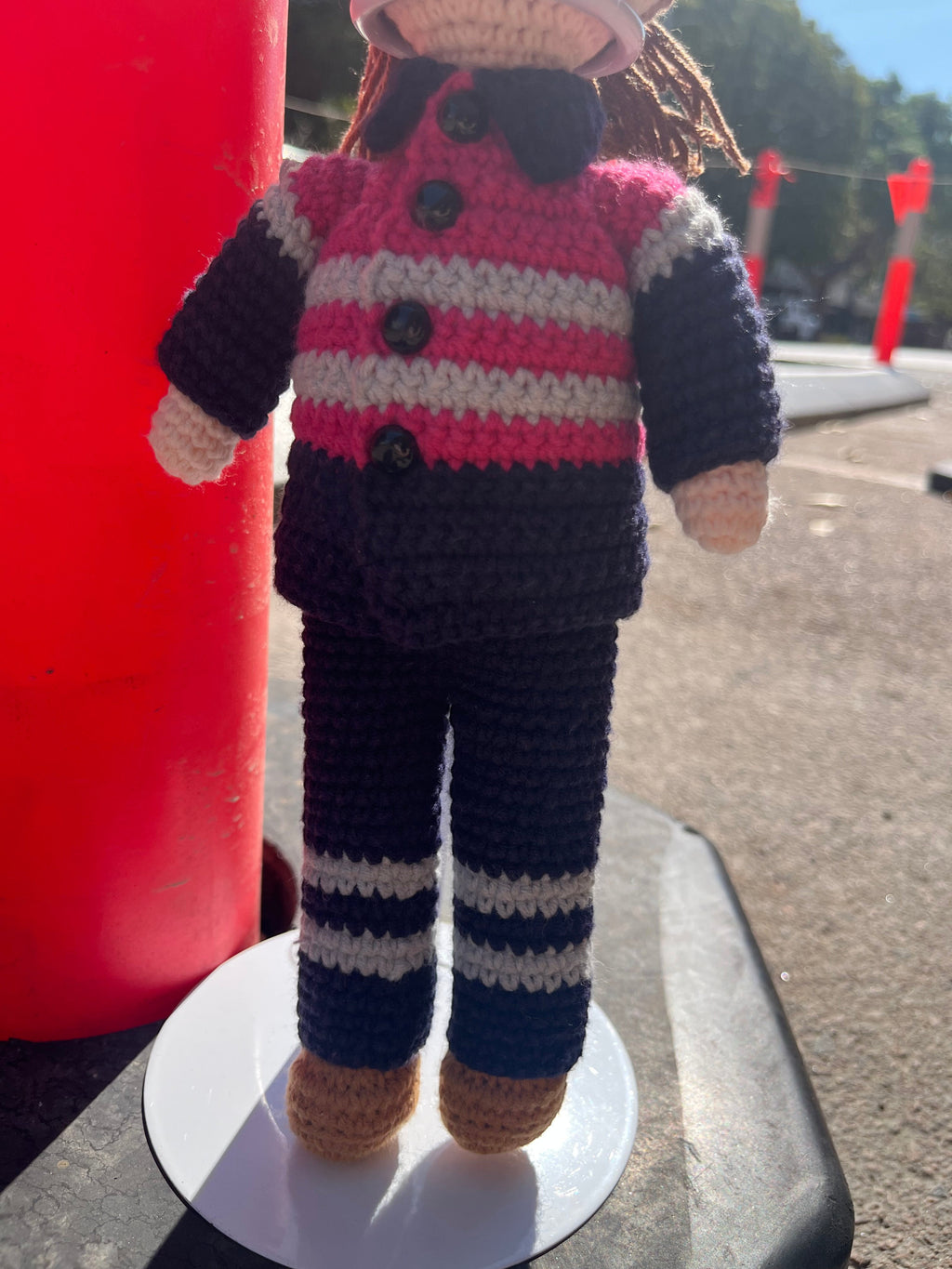 Suzie's Sunshine Dolls Miner/Tradie doll in pink hi-vis, navy pants, and brown boots. Hand-crocheted with reflective stripes.