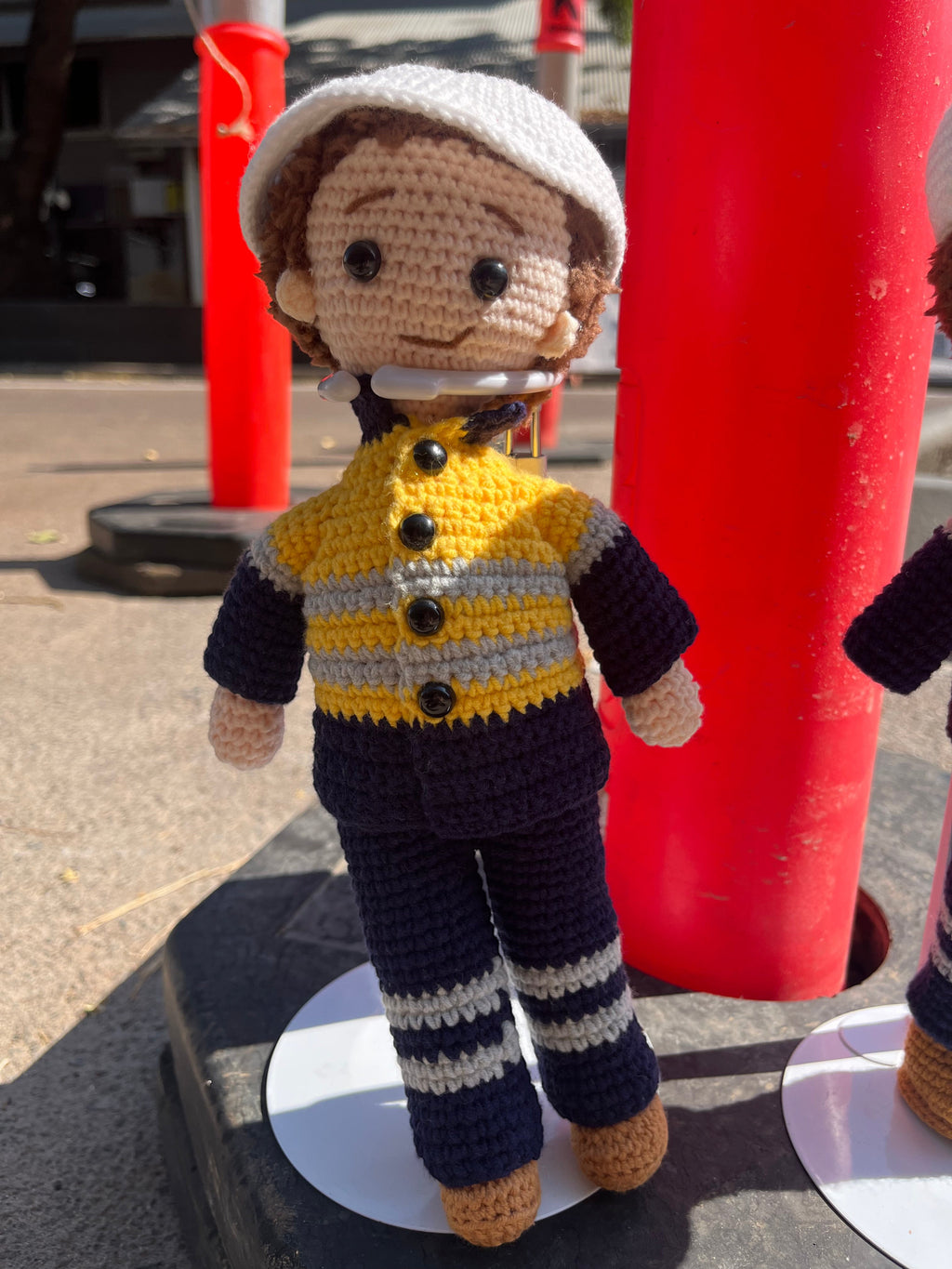 Suzie's Sunshine Dolls Miner/Tradie doll in yellow hi-vis jacket, navy pants, and white cap. Handmade crochet.