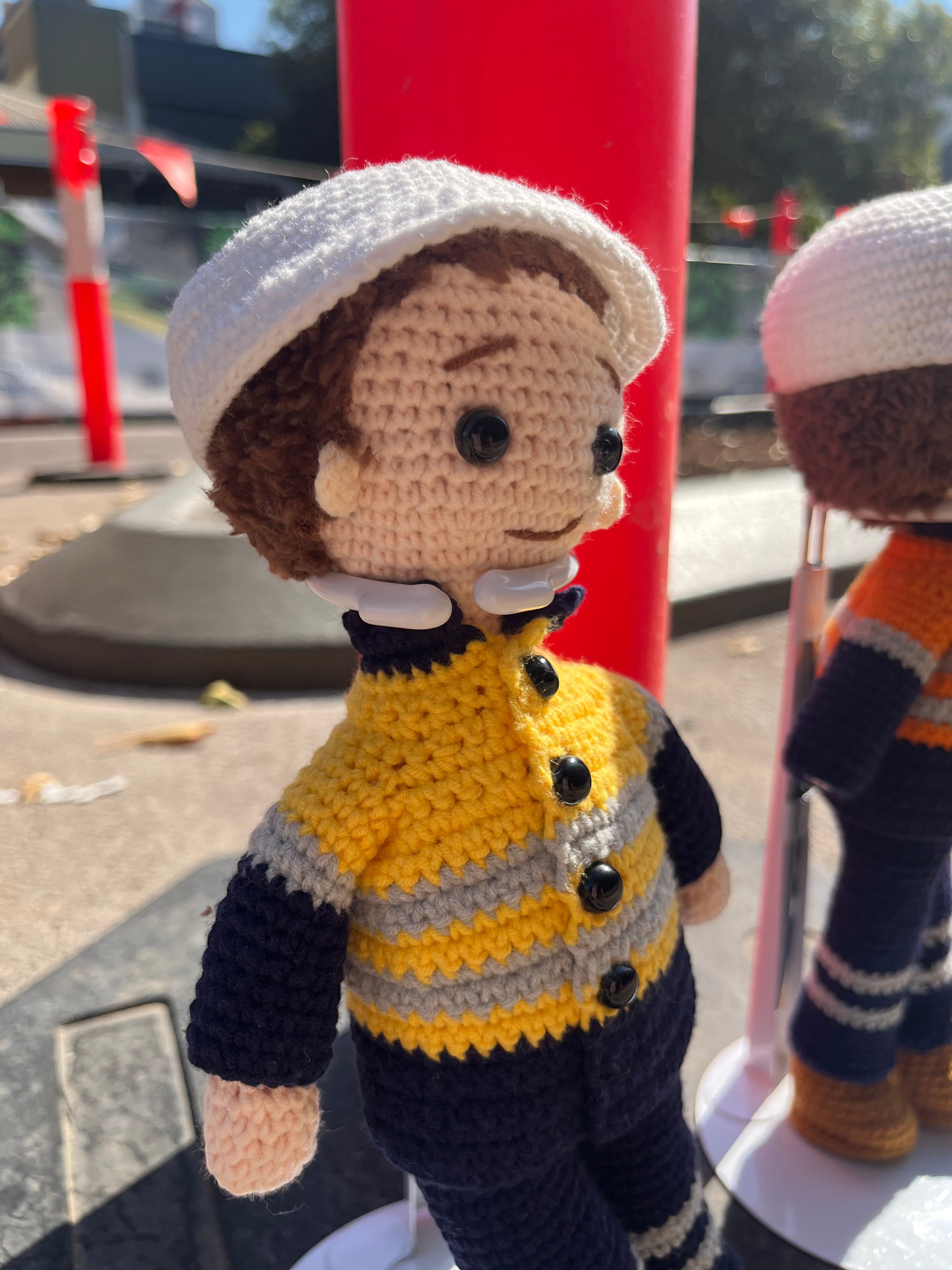 Suzie's Sunshine Dolls Miner/Tradie doll in yellow hi-vis jacket, navy pants, and white cap. Handmade crochet toy.