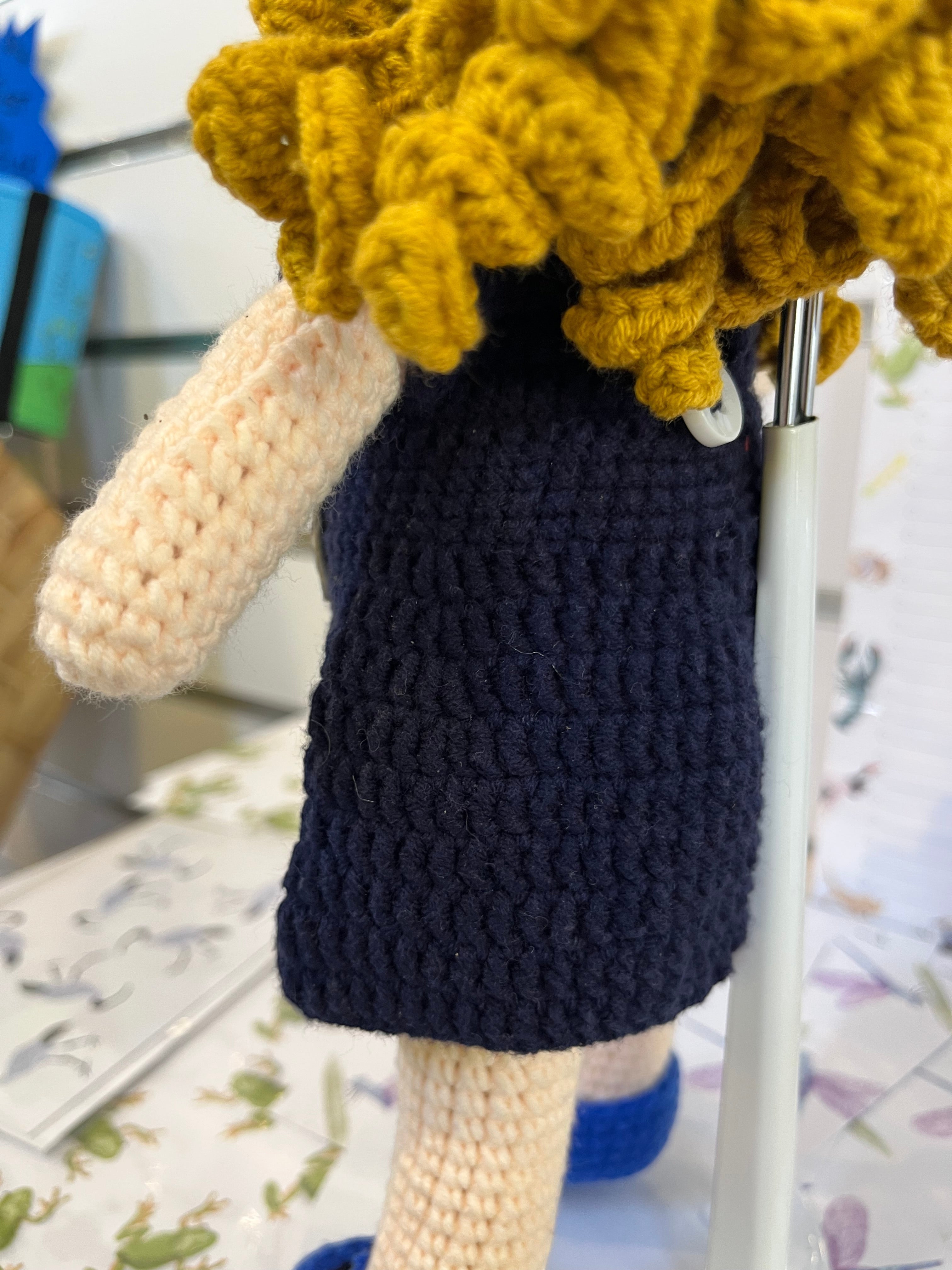Suzie's Sunshine Dolls navy crocheted doll with yellow yarn hair and Cancer Council NT patch detail.