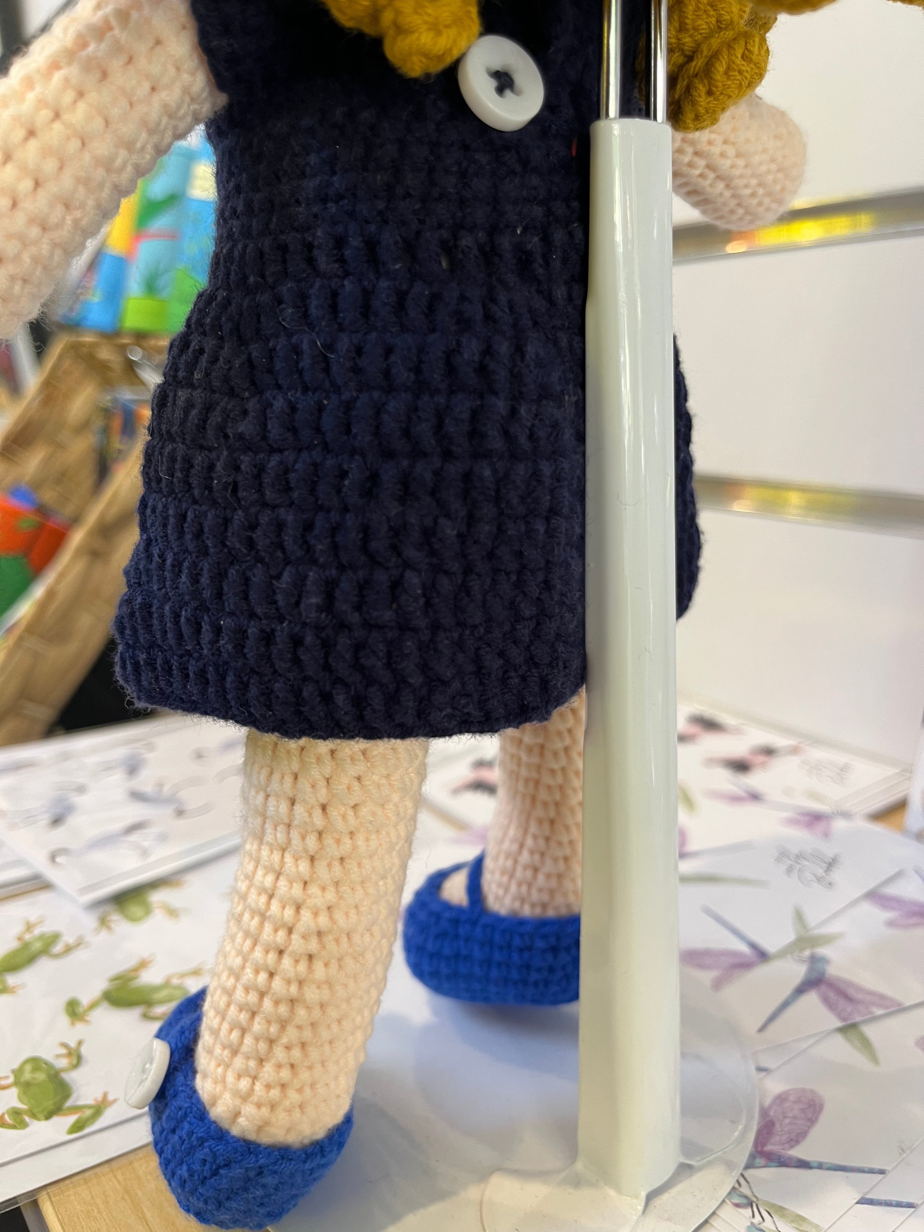 Suzie's Sunshine Dolls navy crocheted doll with yellow hair, white button detail, and blue shoes. Cancer Council NT patch.