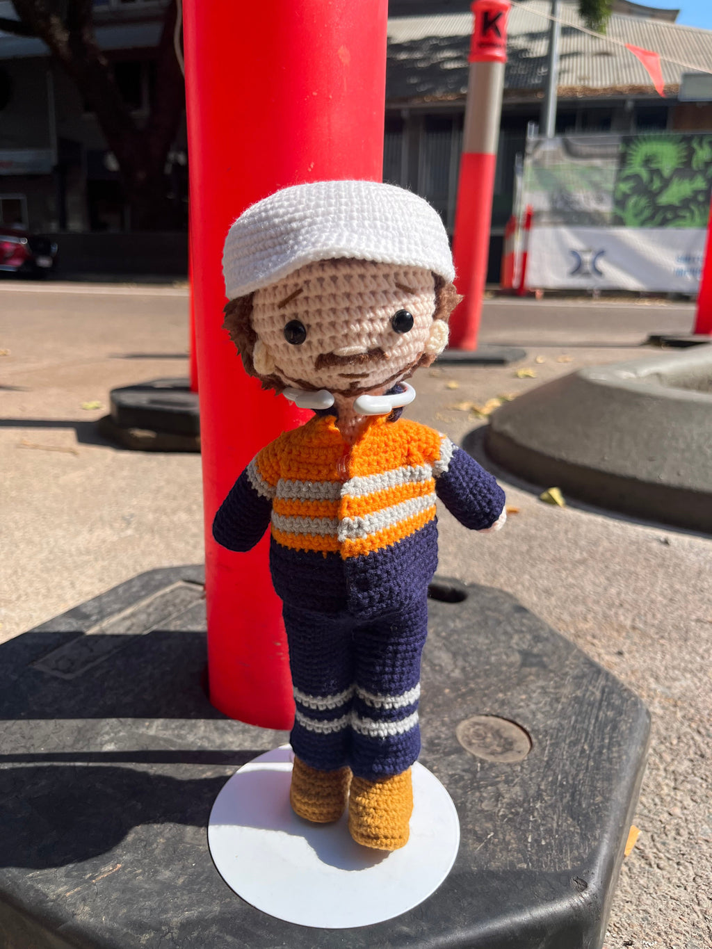 Suzie's Sunshine Dolls Orange Hi-Vis Miner/Tradie doll, crocheted with navy, orange, and grey stripes, wearing a white hard hat.