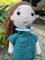 Suzie's Sunshine Dolls Paramedic doll, crocheted in green uniform with brown yarn hair and pink skin. Features black button eyes and a white collar.
