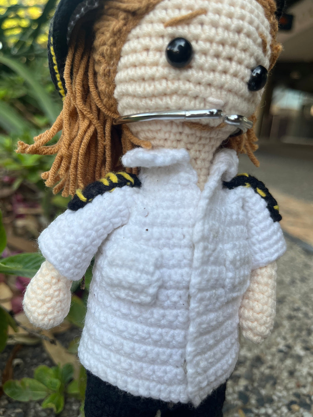 Suzie's Sunshine Dolls handmade crochet pilot doll in uniform with yellow trim and brown yarn hair.