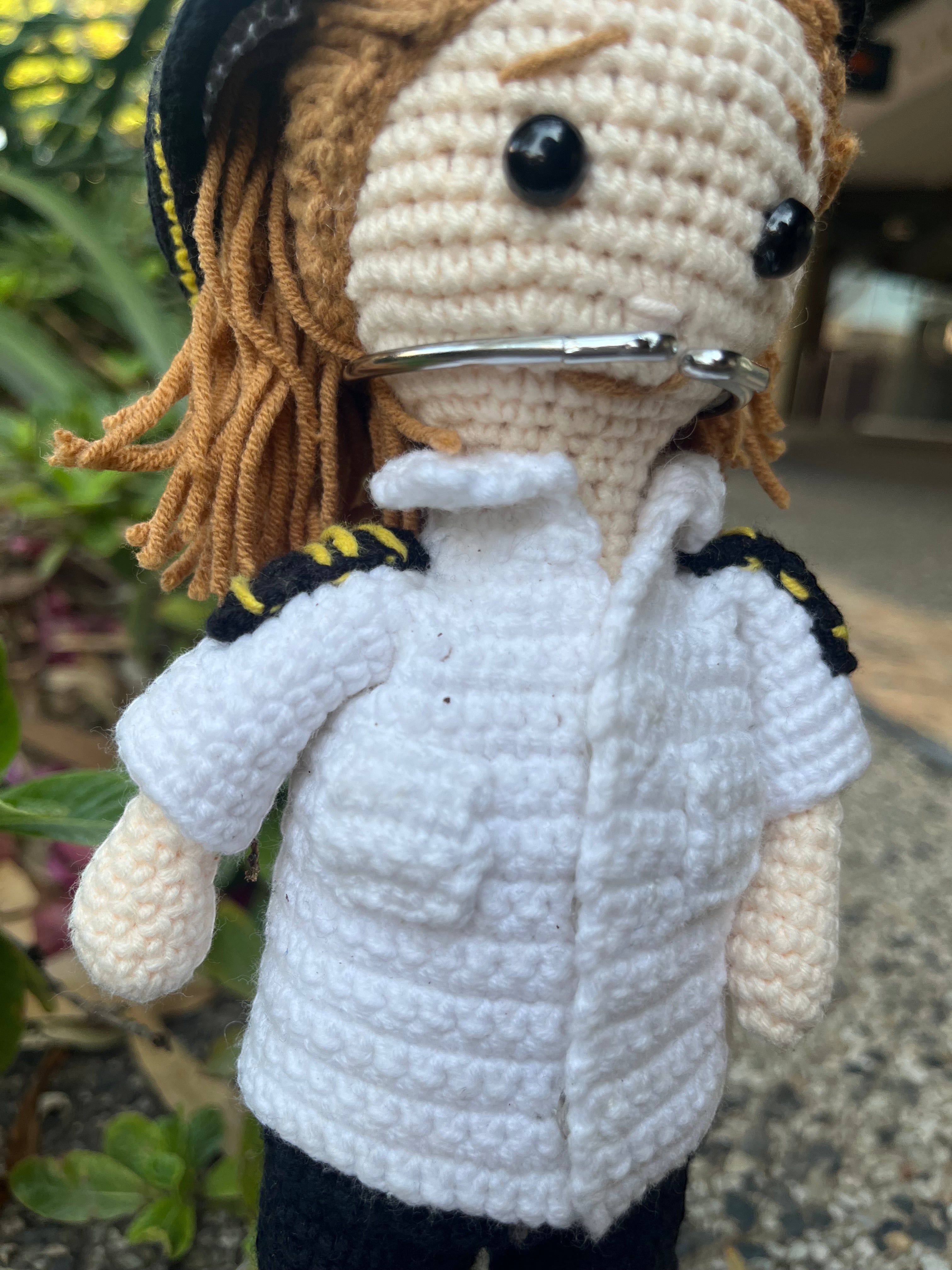 Suzie's Sunshine Dolls handmade crochet pilot doll in uniform with yellow trim and brown yarn hair.