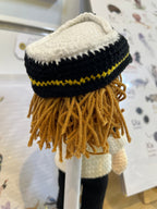 Suzie's Sunshine Dolls handmade crochet pilot doll in uniform with yellow trim hat and brown yarn hair.