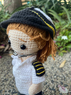 Suzie's Sunshine Dolls handmade crochet pilot doll in white and black  uniform with black and yellow striped epaulets and hat.