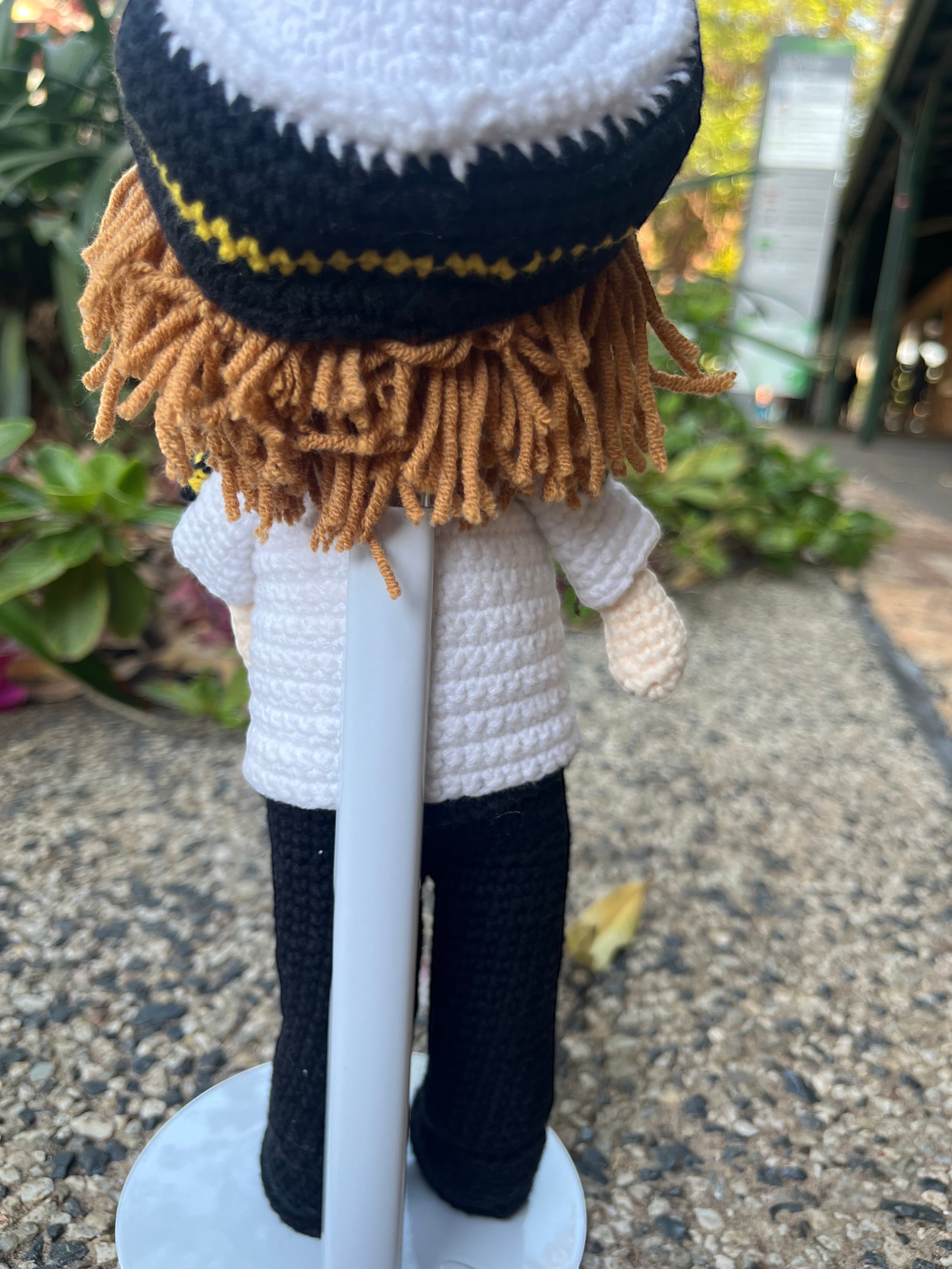 Suzie's Sunshine Dolls handmade crochet pilot doll in uniform with white shirt, black pants, and pilot hat with yellow trim.