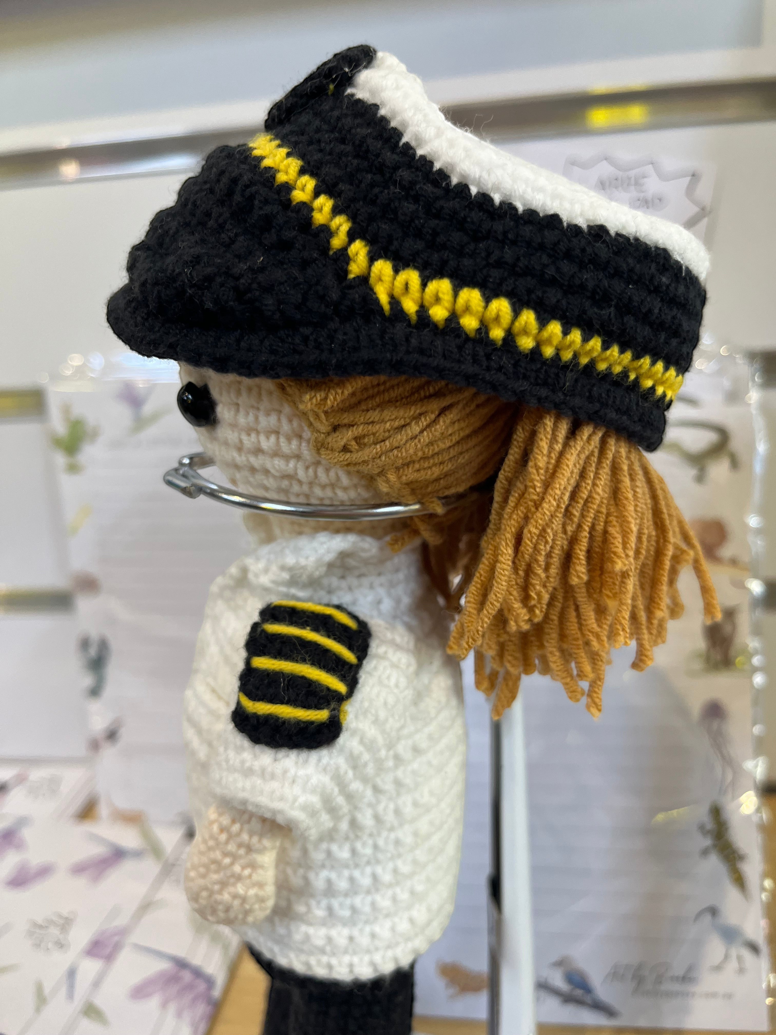 Suzie's Sunshine Dolls handmade crochet pilot doll in uniform with yellow stripes and black cap.