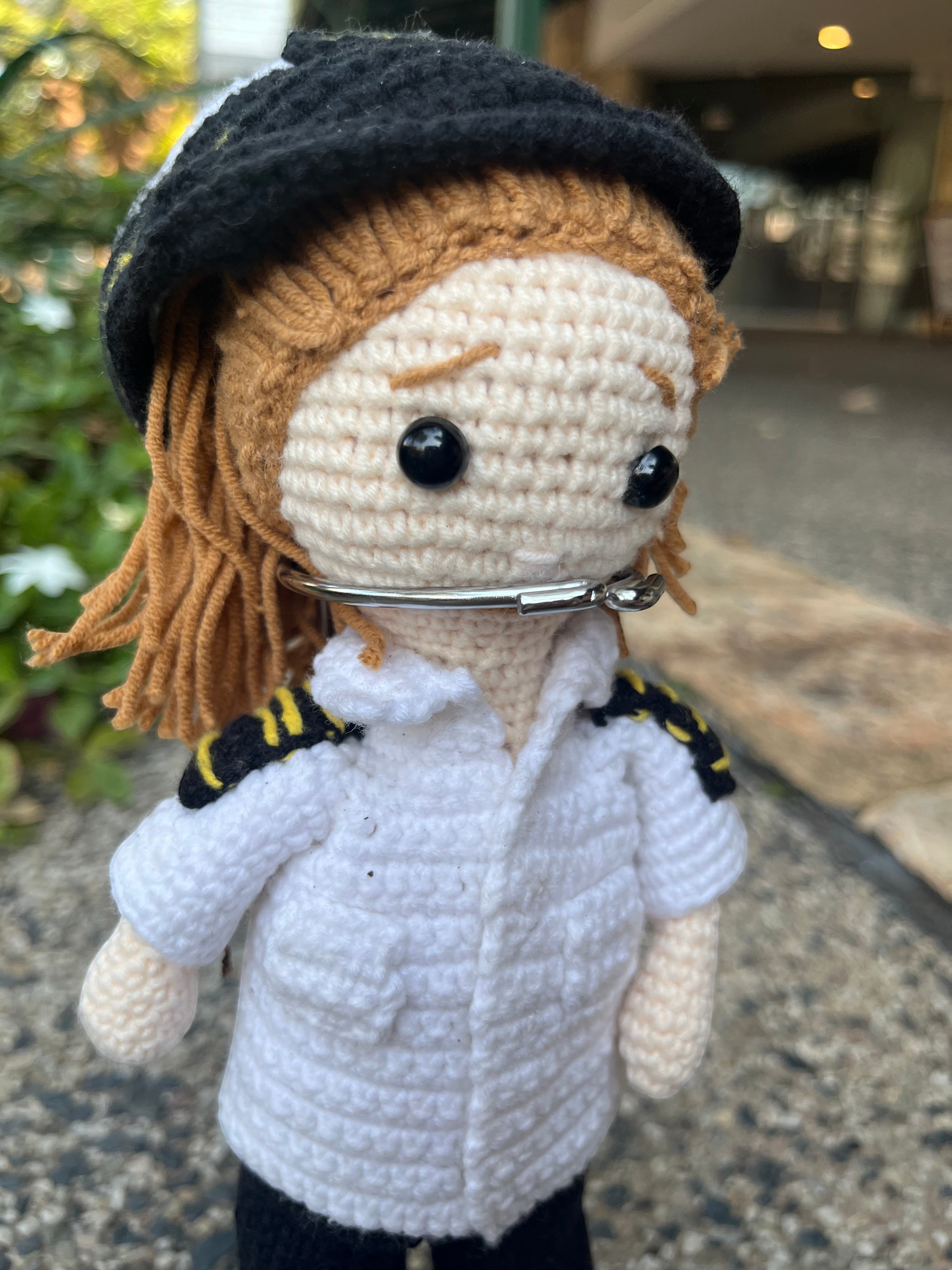 Suzie's Sunshine Dolls handmade crochet pilot doll in uniform with black hat and yellow trim.