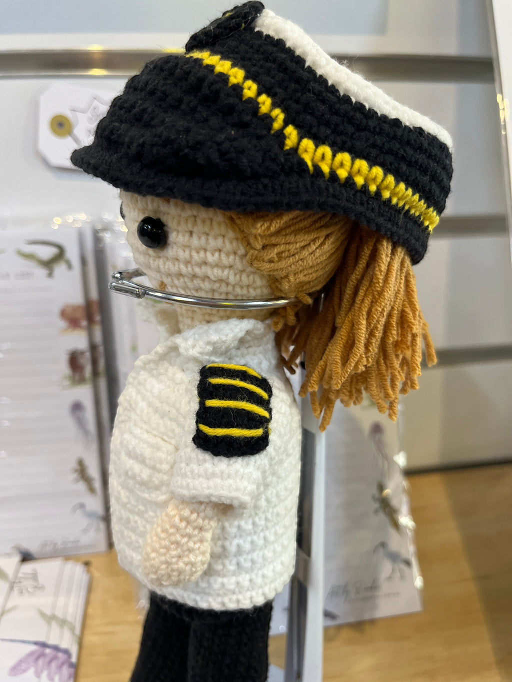 Suzie's Sunshine Dolls handmade crochet pilot doll in uniform with yellow stripes on hat and sleeve patch.