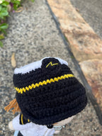 Suzie's Sunshine Dolls handmade crocheted pilot doll in uniform with black hat, yellow trim, and white shirt.