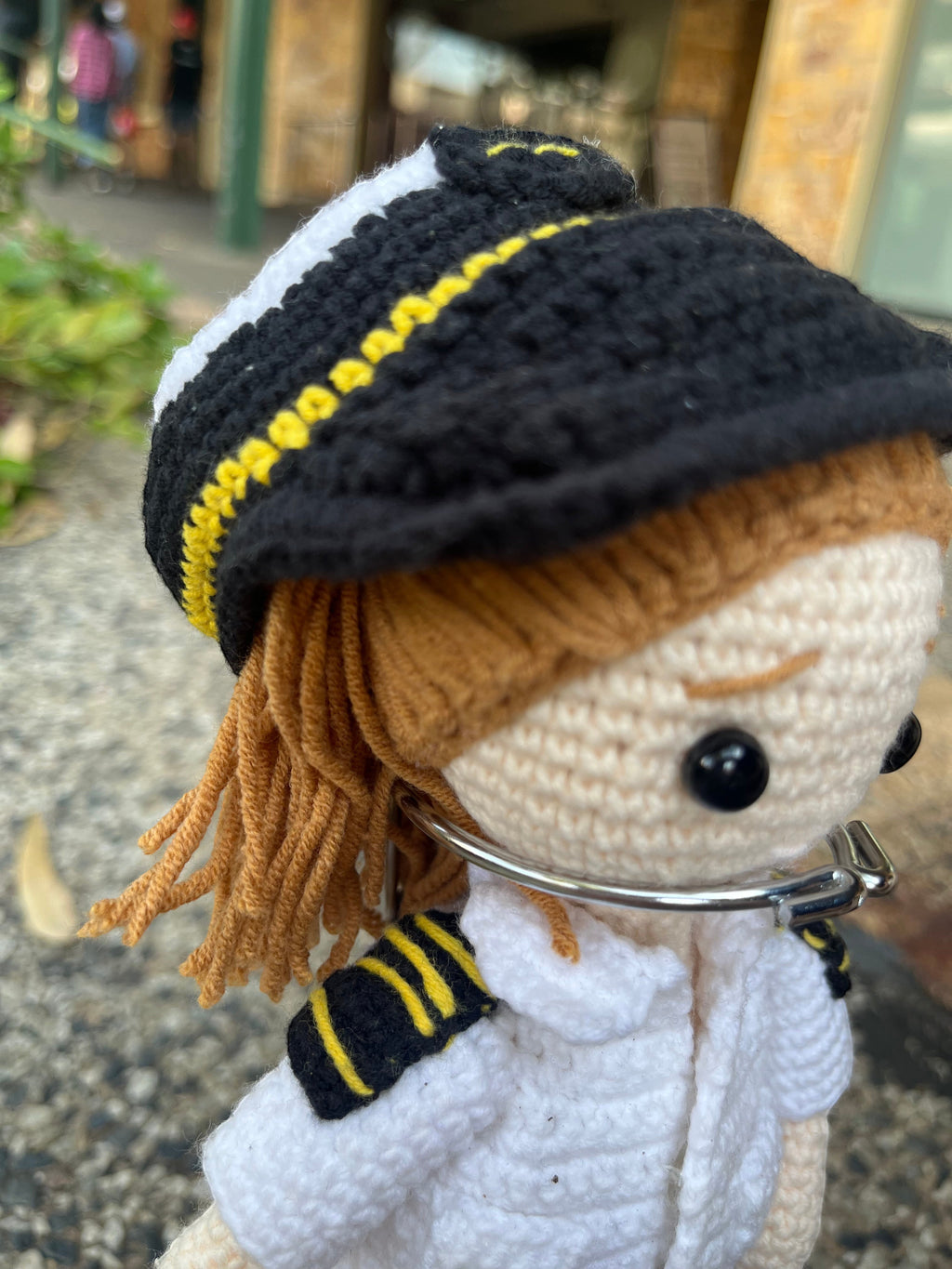 Suzie's Sunshine Dolls handmade crocheted pilot doll in uniform with yellow stripes on shoulders and hat.