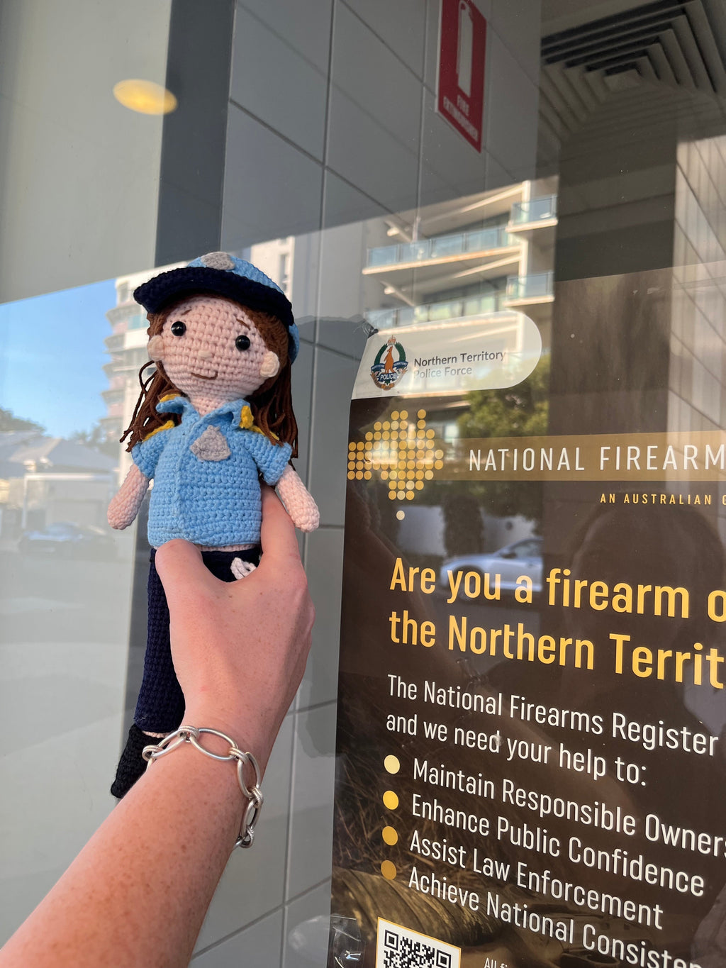 Suzie's Sunshine Dolls crocheted police officer doll in blue uniform with cap and badge. Handcrafted yarn toy.