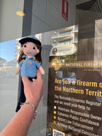 Suzie's Sunshine Dolls crocheted police officer doll in blue uniform with cap and badge. Handcrafted yarn toy.