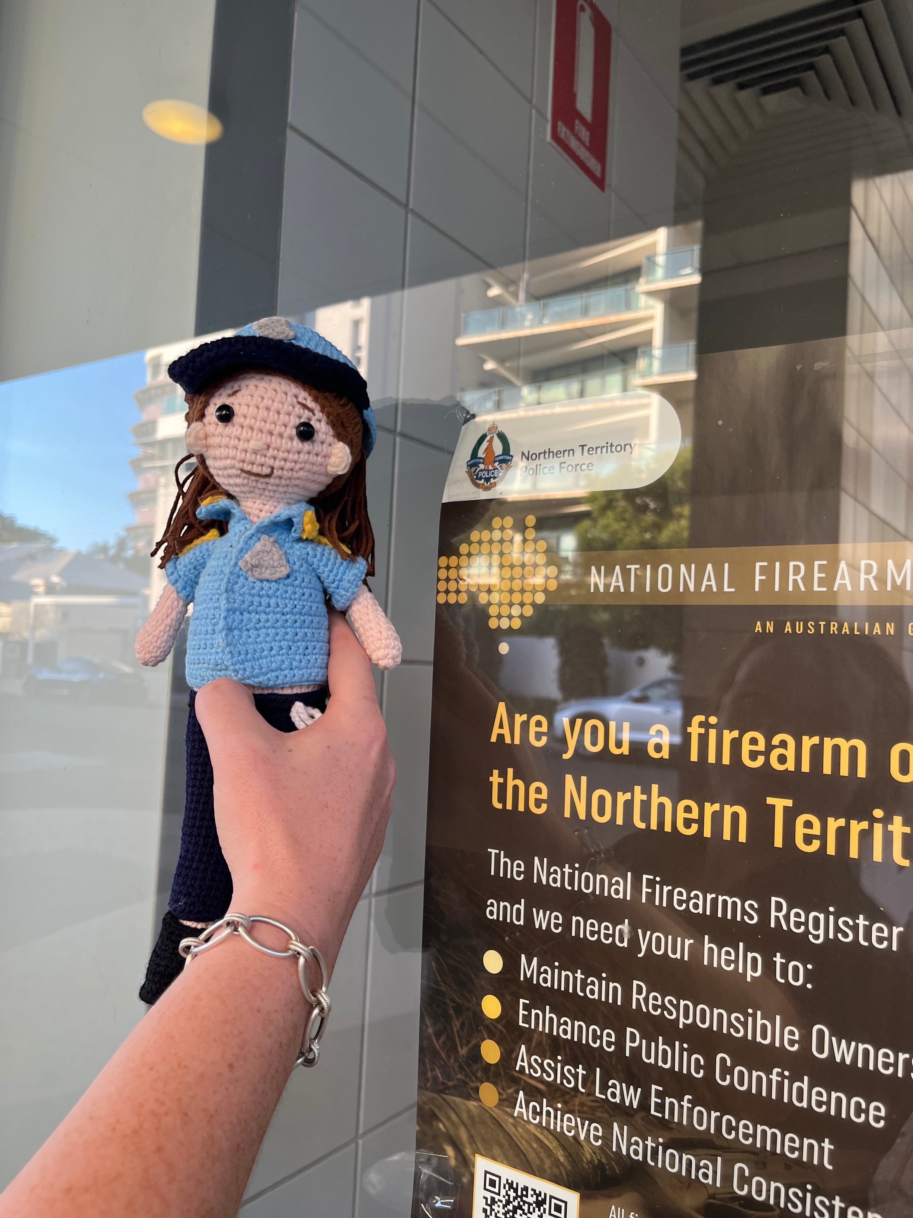 Suzie's Sunshine Dolls crocheted police officer doll in blue uniform with cap and badge. Handcrafted yarn toy.