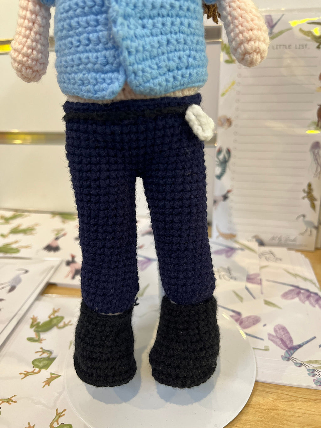 Suzie's Sunshine Dolls Policeman doll, crocheted blue shirt, navy pants, black boots, and white pocket detail.
