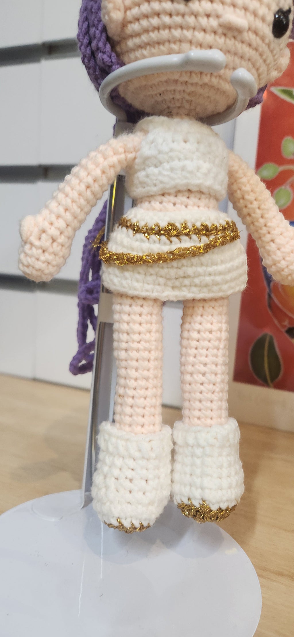 Suzie's Sunshine Dolls Rumi K-Pop Demon Hunter amigurumi doll in white outfit with gold trim and purple hair.