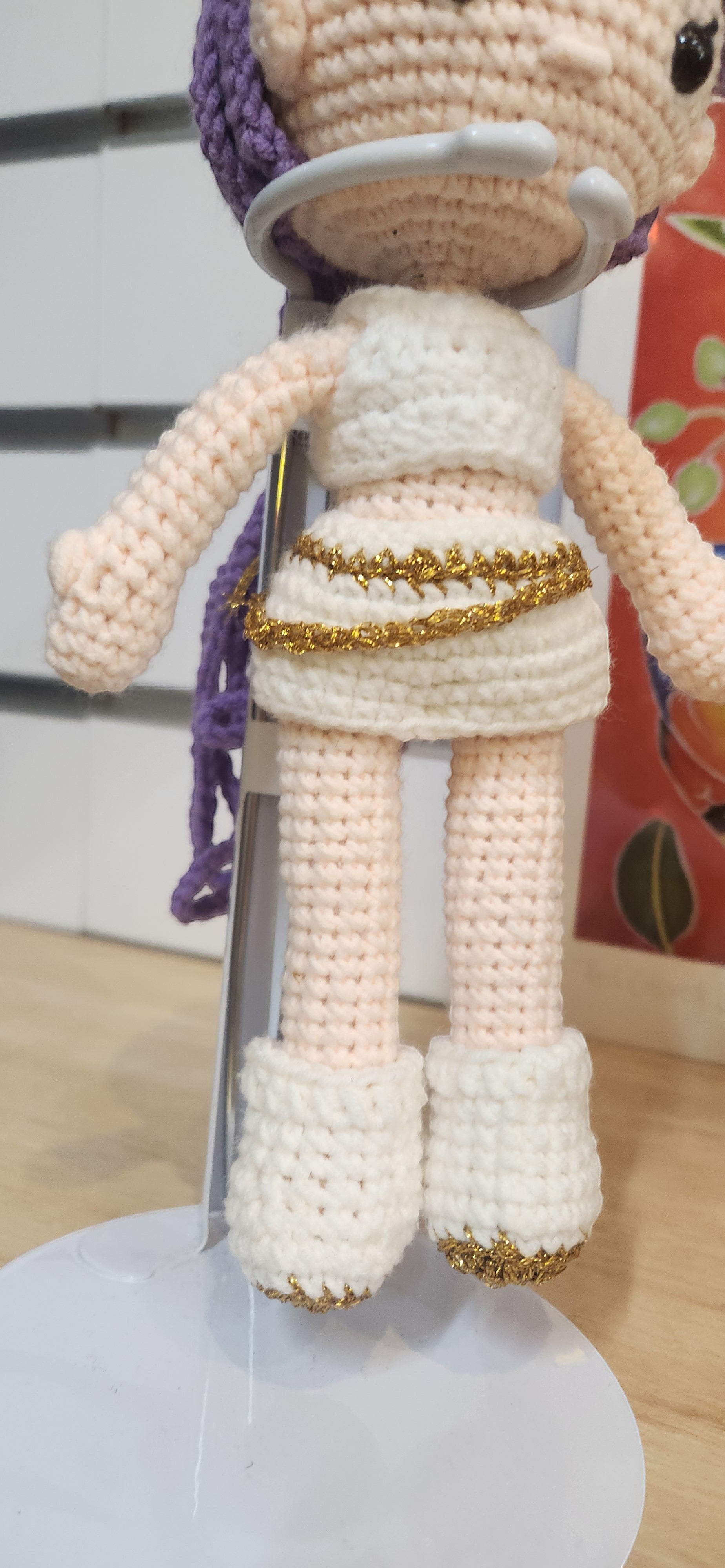 Suzie's Sunshine Dolls Rumi K-Pop Demon Hunter amigurumi doll in white outfit with gold trim and purple hair.