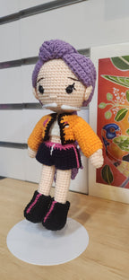 Suzie's Sunshine Dolls Rumi K-Pop Demon Hunter amigurumi doll with purple hair, orange jacket, and black shorts.