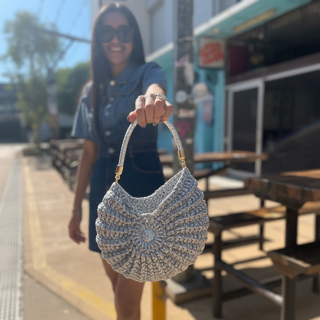 Suzie's Sunshine Dolls silver crochet shoulder bag with braided handle and embellished center. Crescent shape.