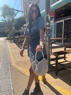 Suzie's Sunshine Dolls silver crochet shoulder bag with braided handle, crescent shape, textured detail.