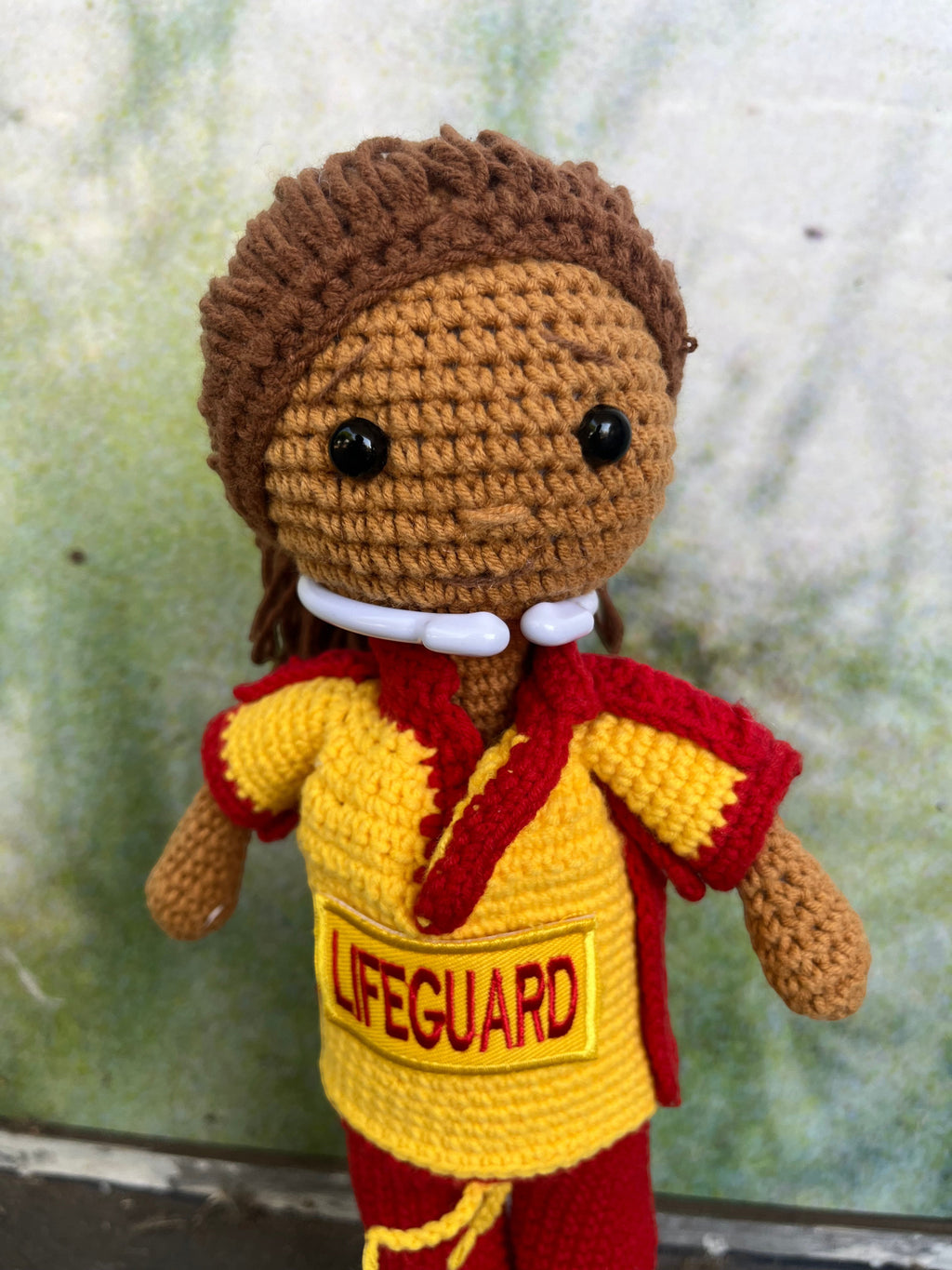 Suzie's Sunshine Dolls handmade crocheted surf lifesaver doll in red and yellow uniform with "LIFEGUARD" patch.
