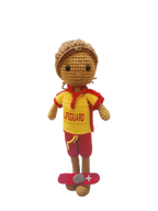 Suzie's Sunshine Dolls handmade crocheted surf lifesaver doll in red and yellow uniform with 'LIFEGUARD' text, standing on a red rescue float.