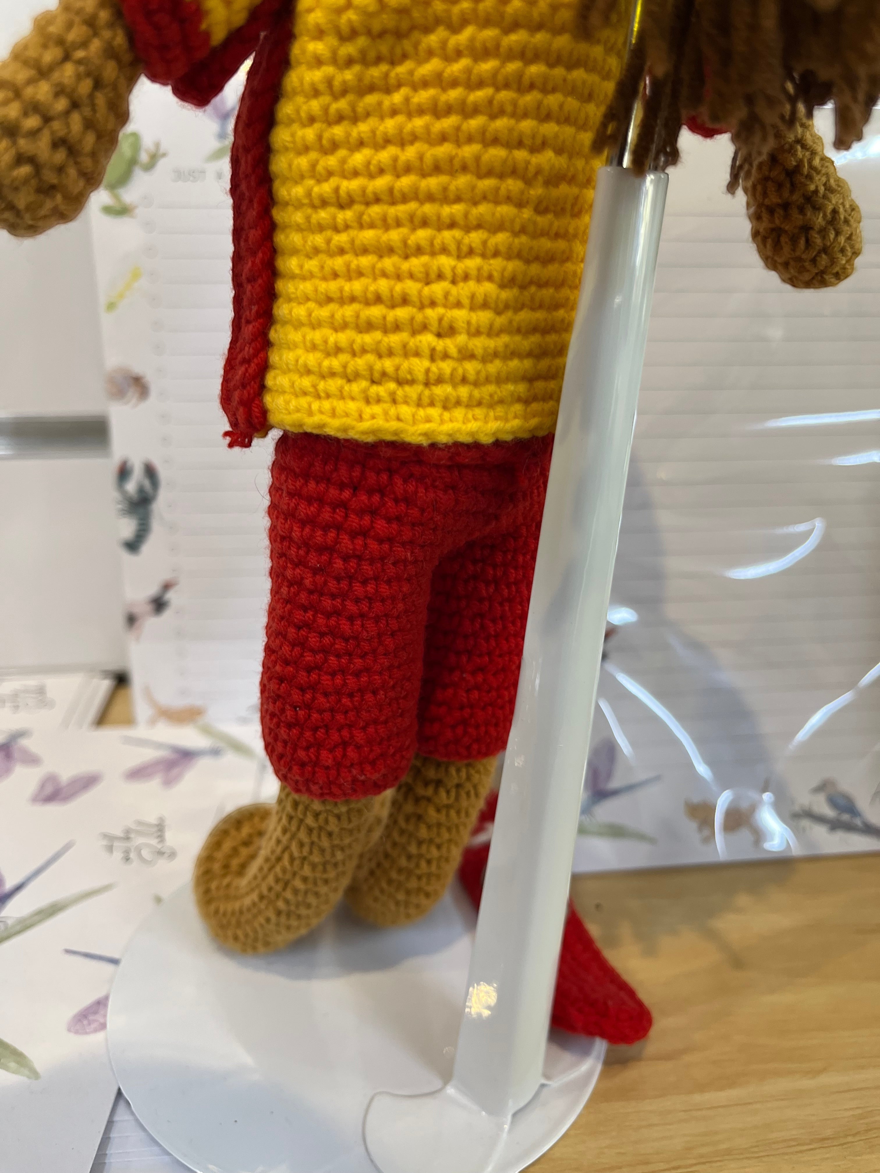 Suzie's Sunshine Dolls Surf Lifesaver doll in red shorts and yellow rashie, handmade from yarn.