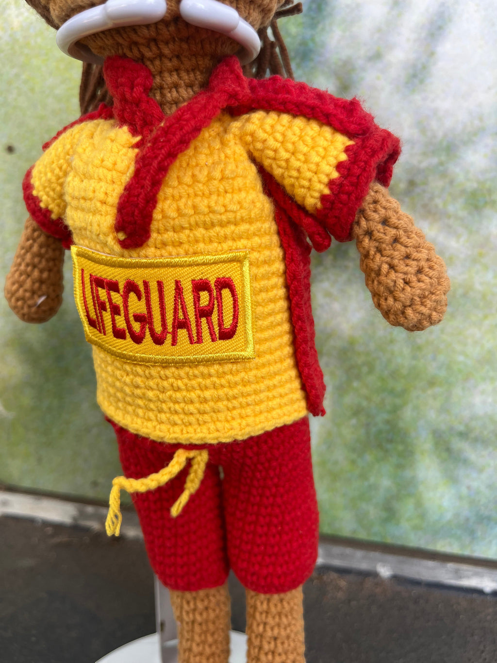 Suzie's Sunshine Dolls Surf Lifesaver doll in red shorts and yellow rashie with red trim, featuring "LIFEGUARD" patch.