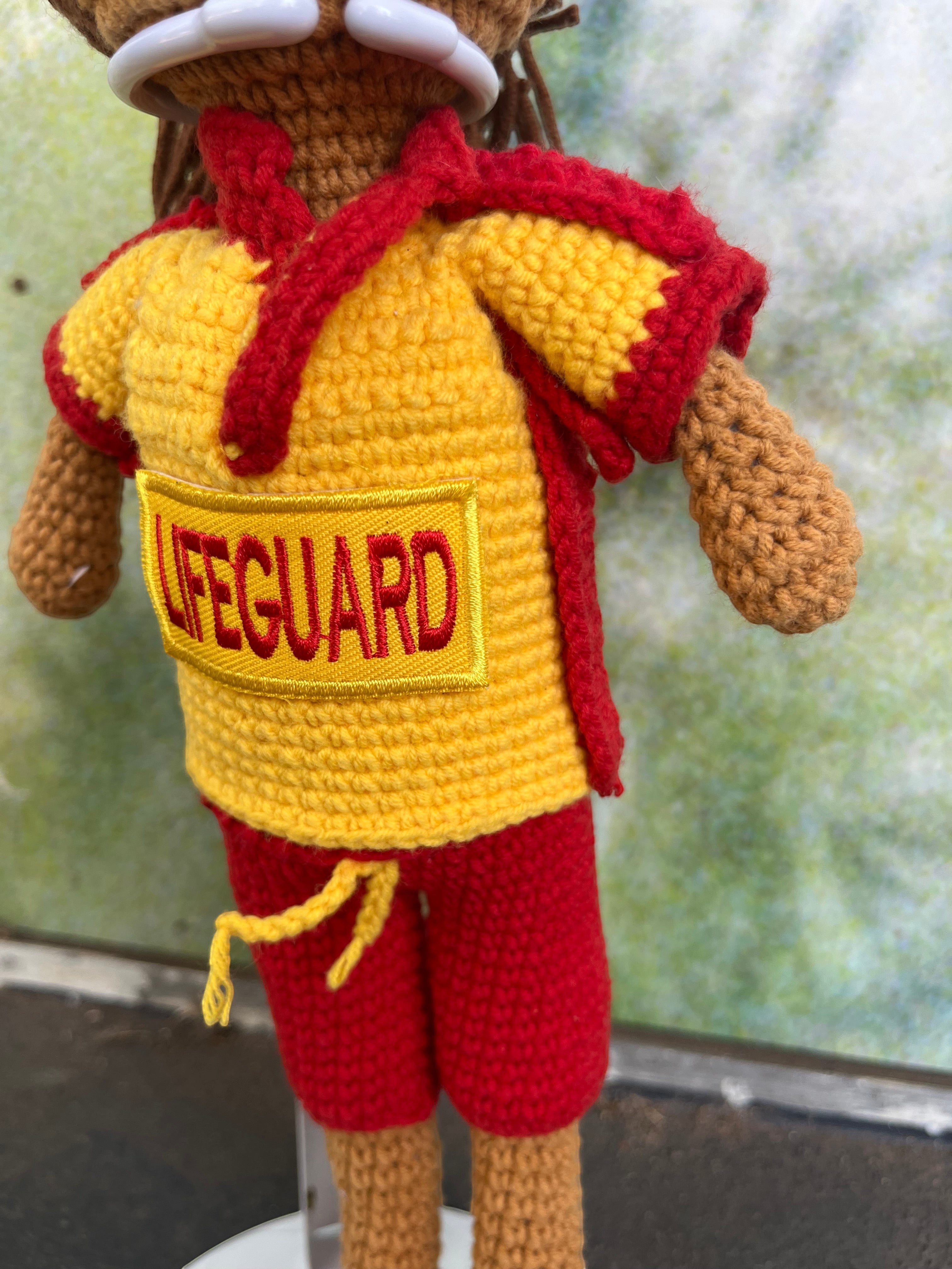 Suzie's Sunshine Dolls Surf Lifesaver doll in red shorts and yellow rashie with red trim, featuring "LIFEGUARD" patch.