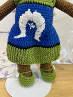 Suzie's Sunshine Dolls Leilani, a handmade crochet doll with long black hair, wearing a blue dress with white Dhari and star, and green shoes.