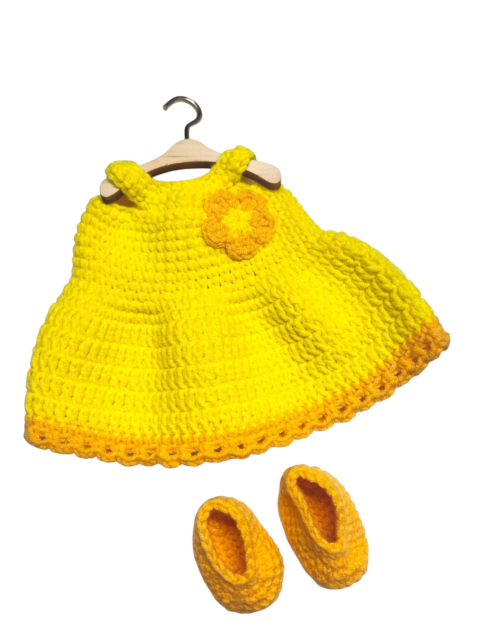 Suzie's Sunshine Dolls yellow crochet doll dress with orange trim and flower detail, with matching booties. Handmade yarn.