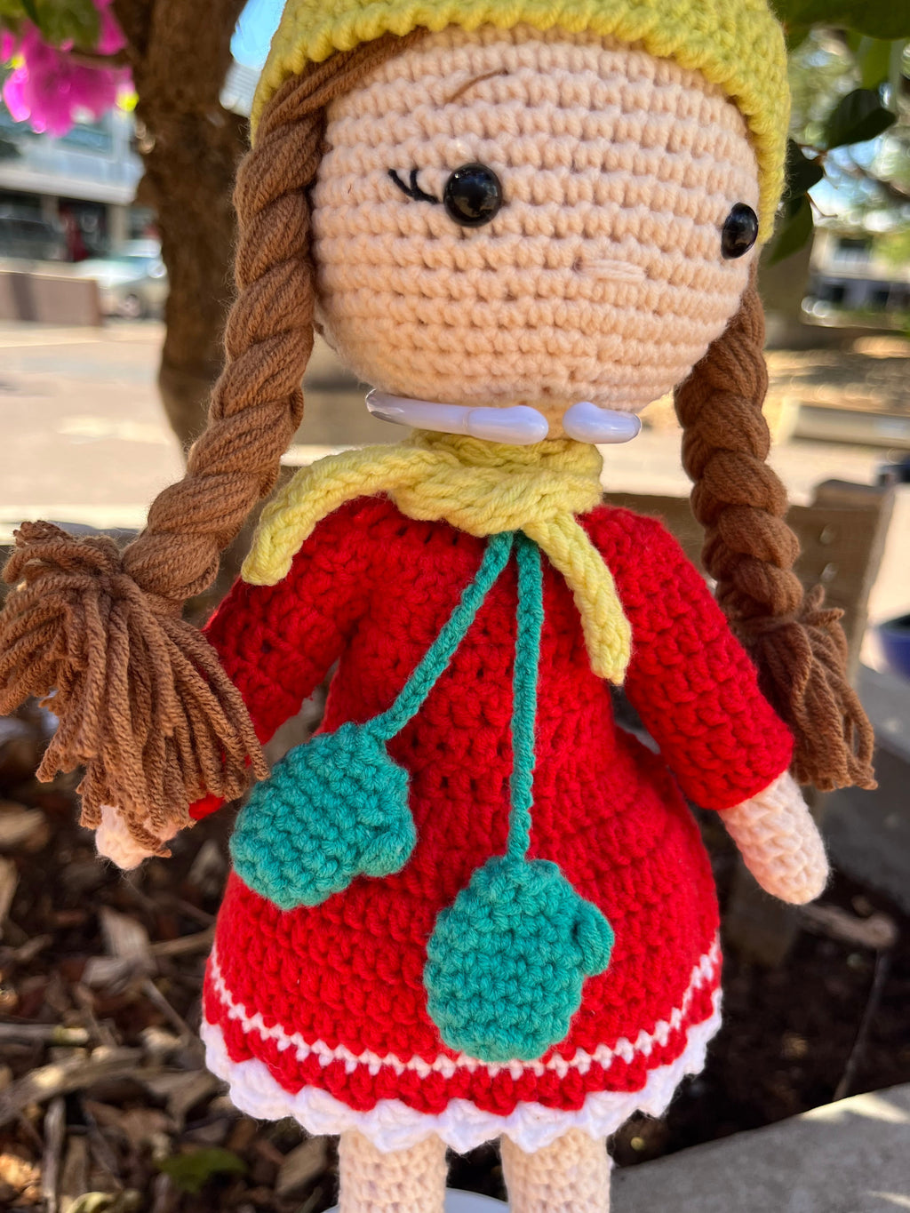 Suzie's Sunshine Dolls Zoey doll in red crocheted dress, yellow beanie, and turquoise scarf with mittens.